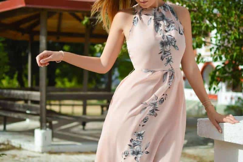 mulher com vestido floral preto cor-de-rosa