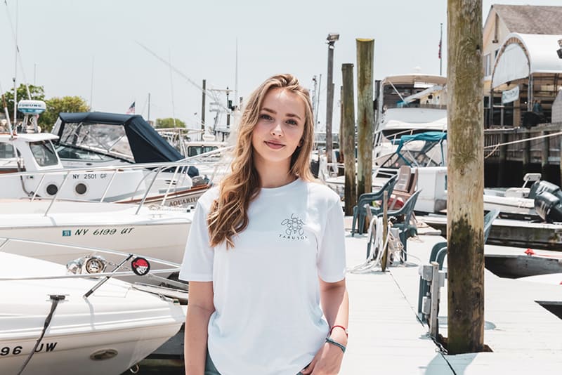 woman wearing white t-shirt while standing in the harbor
