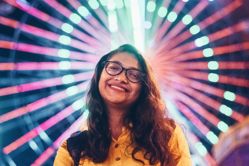 mujer con camisa amarilla y gafas de montura negra