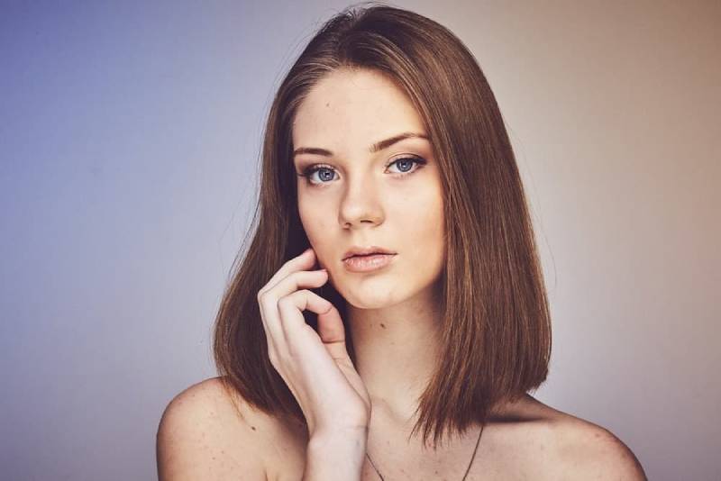 woman with her hand and cheek with simple makeup