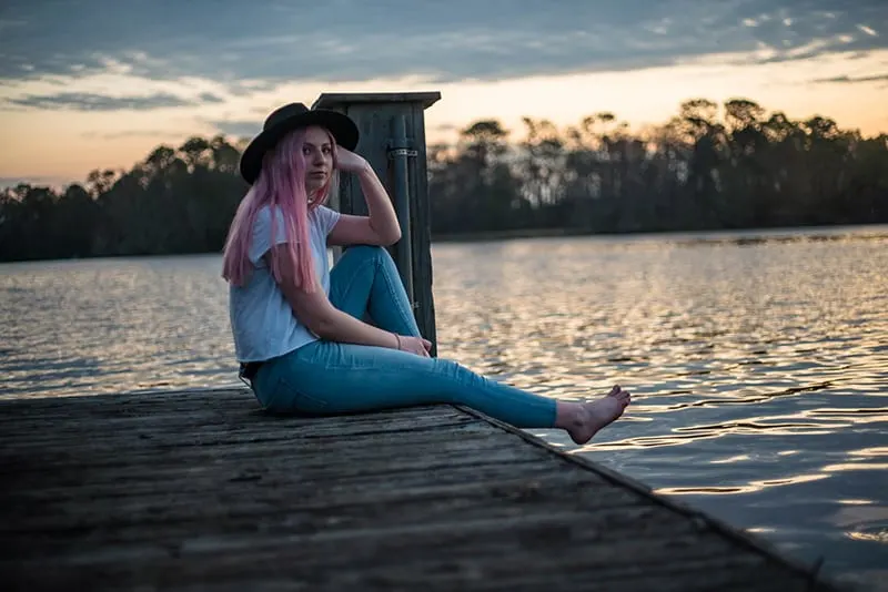 woman with pink hair sitting on the dock