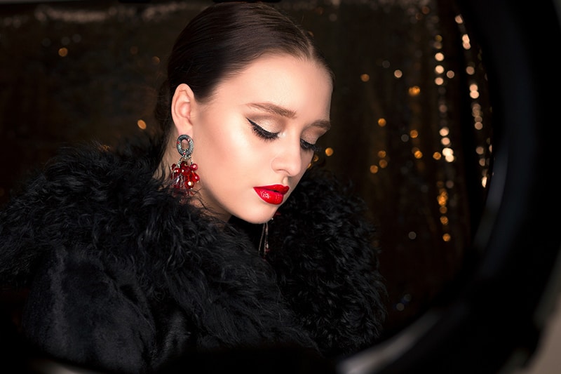 woman with red lips wearing red earrings