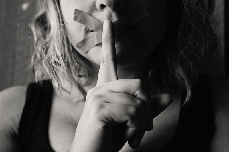 donna con labbra sigillate con nastro adesivo firmata silenzio in bianco e nero