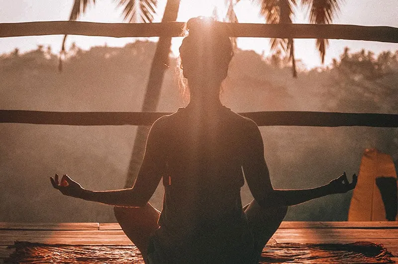 woman yoga pose meditating at sunrise