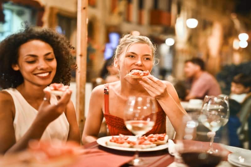 dos mujeres comiendo bruschetta en un restaurante