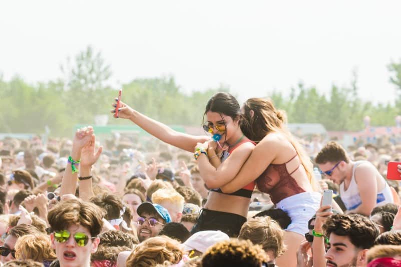 two women embracing surrounded by crowd