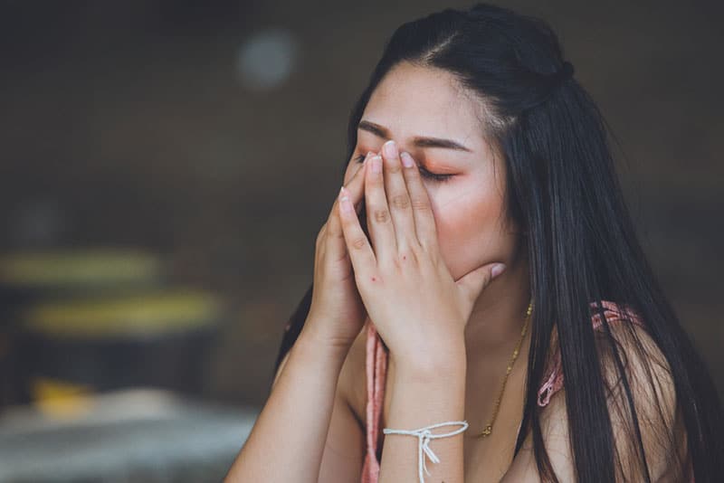 worried woman holding hands on face