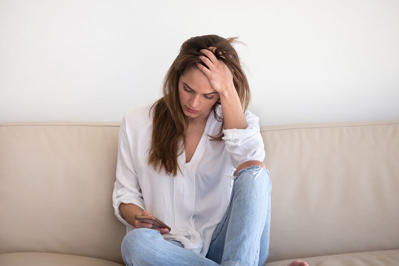 mujer preocupada mirando el teléfono