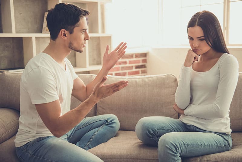 young man talking to woman in the living room