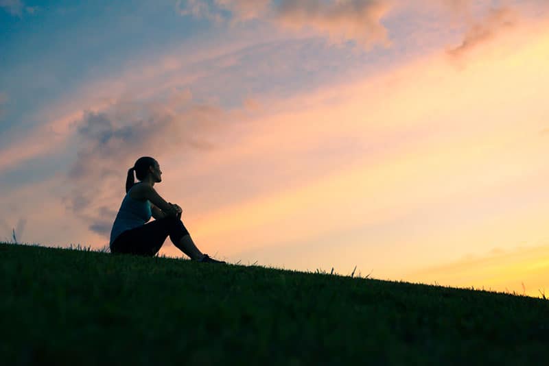 young woman sitting on the hill