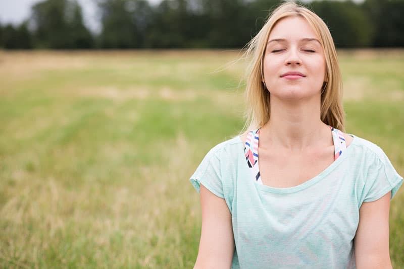 young woman with closed eyes taking a deep breath