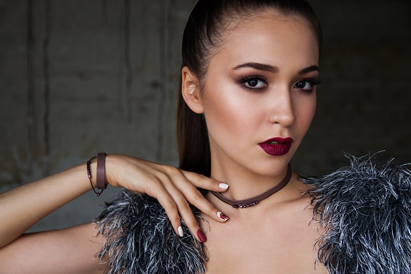 young woman with red lips touching the neck with her hand