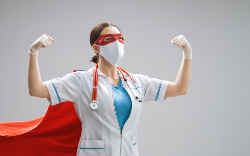 Nurse wearing mask and superhero costume. 