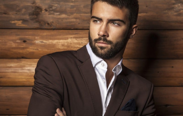 Handsom man standing against wooden wall