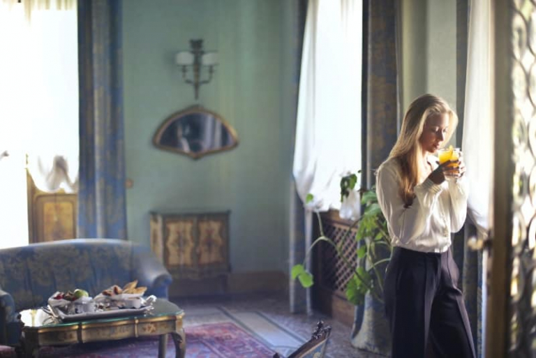 woman in white shirt drinking orange juice
