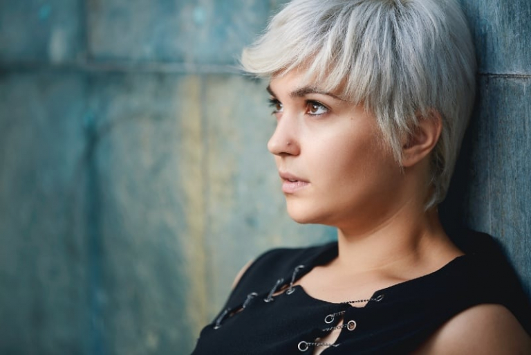 woman in black top leaning on wall