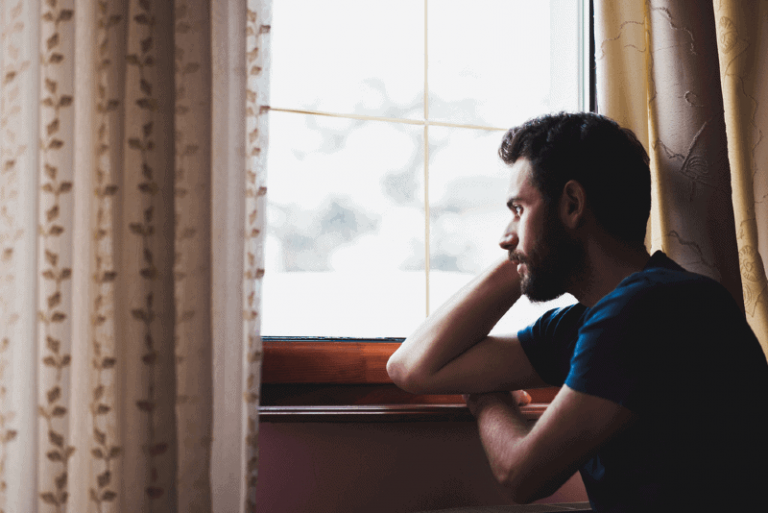 man looking through window during daytime