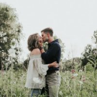 homem e mulher a beijarem-se num campo relvado
