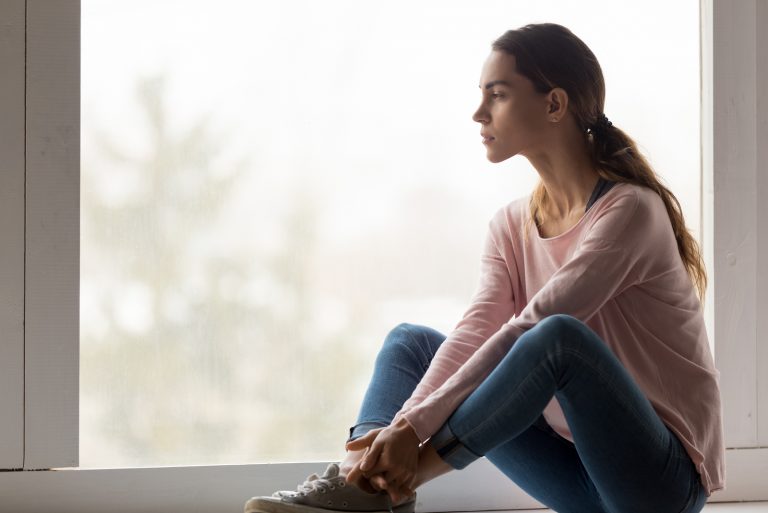sad woman sitting by the window