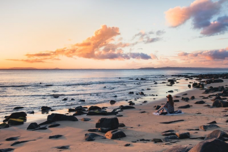 woman sitting on seashore looking at sea