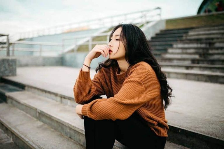 a sad woman is sitting on the stairs