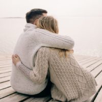 the couple hugging on a wooden pier