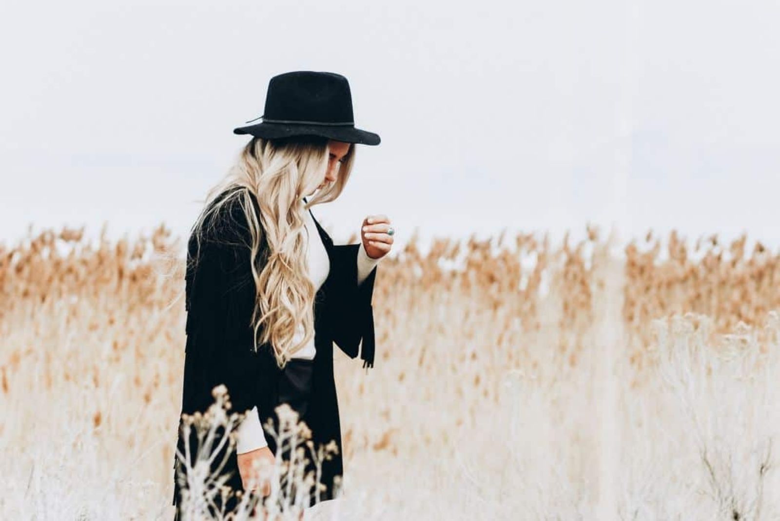 a zen of long blue hair with a black hat standing in a field