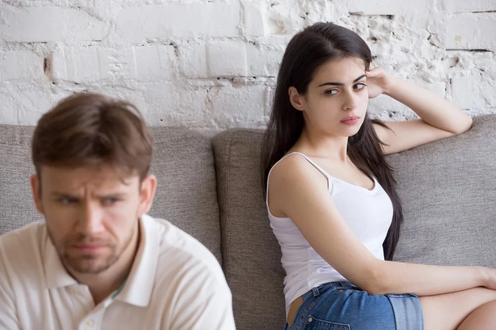 a frustrated woman looks at an angry man after an argument