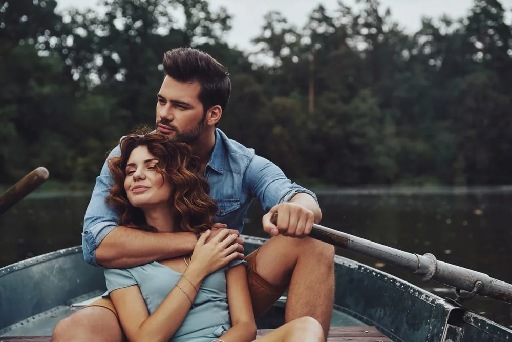 a loving couple sitting in a boat and enjoying themselves