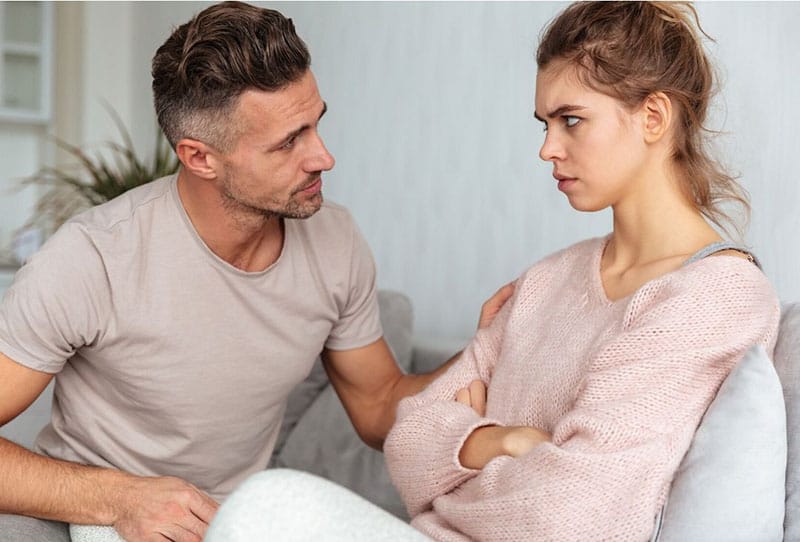 attentive man to his angry wife touching her shoulders