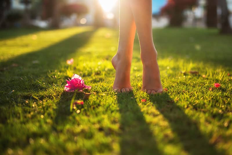 donna a piedi nudi in piedi sull'erba