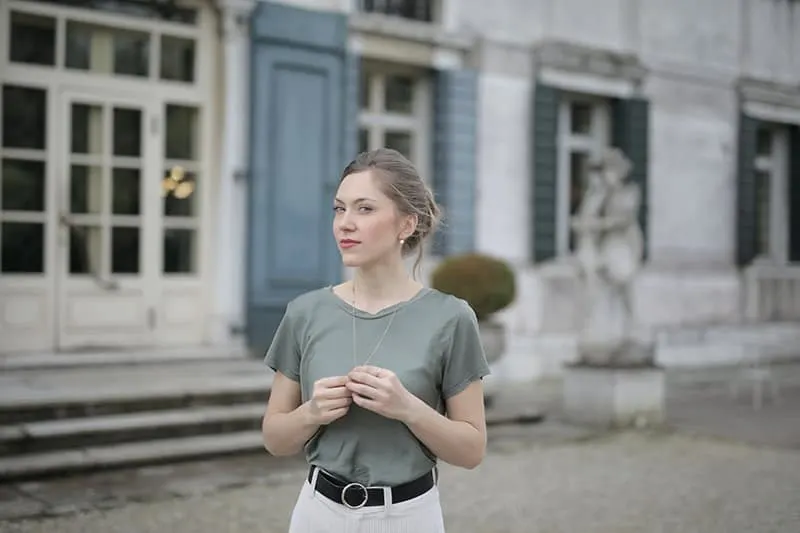 beautiful young woman standing in front of buildings