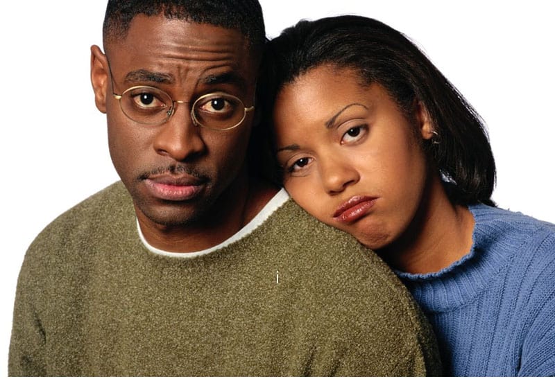 black man beside a woman wearing blue top in focus