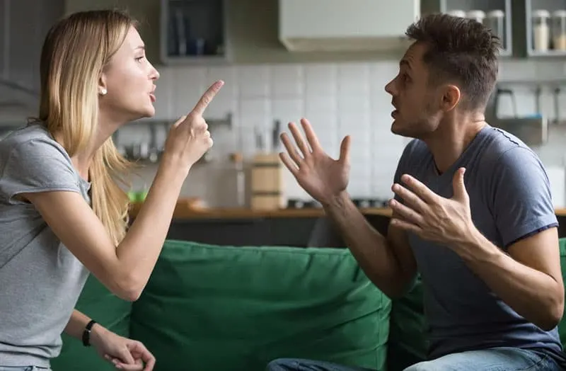 couple fighting over couch near the kitchen