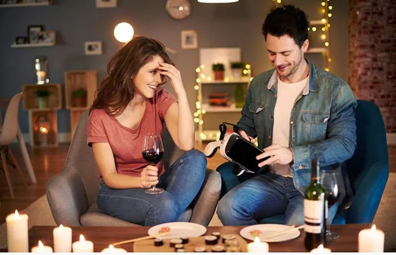 couple inside home holding a VR and having a wine and dine night
