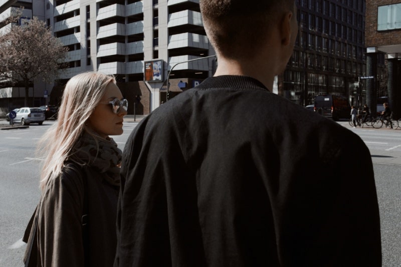 woman with sunglasses and man looking at the street