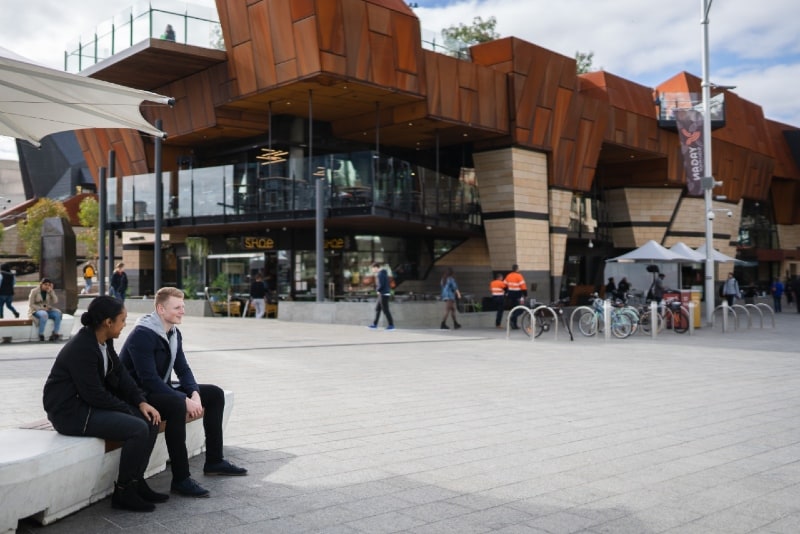 man and woman sitting near water fountain during daytime