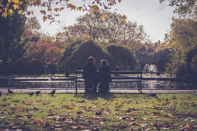 uomo e donna seduti su una panchina vicino all'acqua