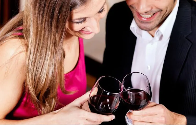 couple's wine glass bumped with couple close to each other in downward angle
