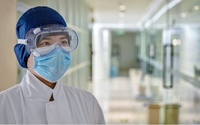 Covid nurse wiith mask on hospital hallway