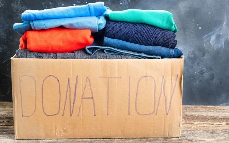 donation box filled with old clothes of different colors