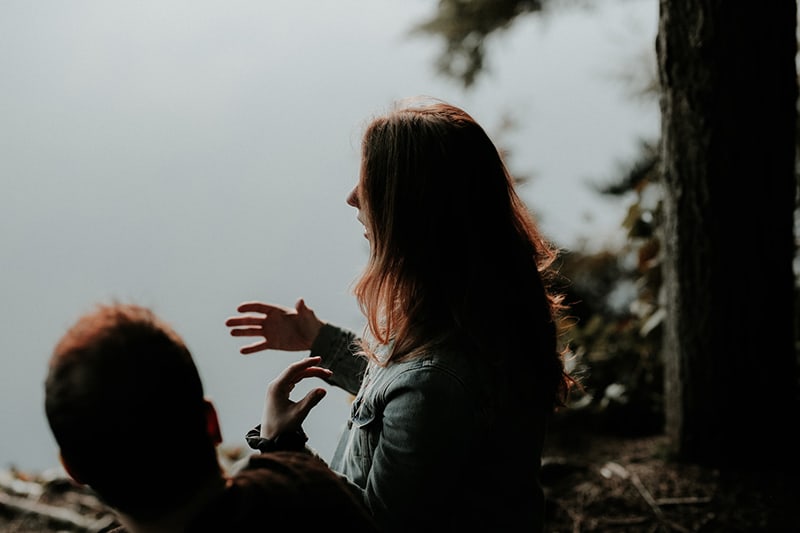 girl standing beside men near the body of water