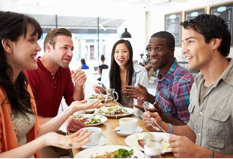 group of friends eating while chatting inside a cafe