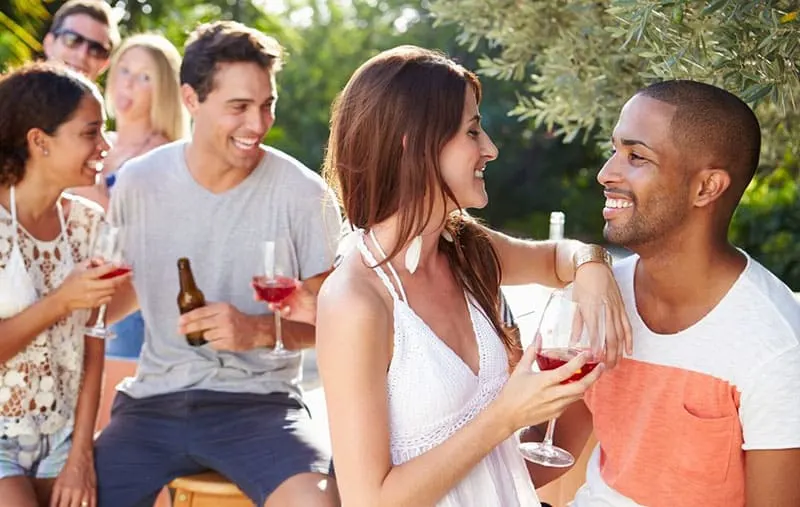 group of friends in an outdoor party drinking wine and beer