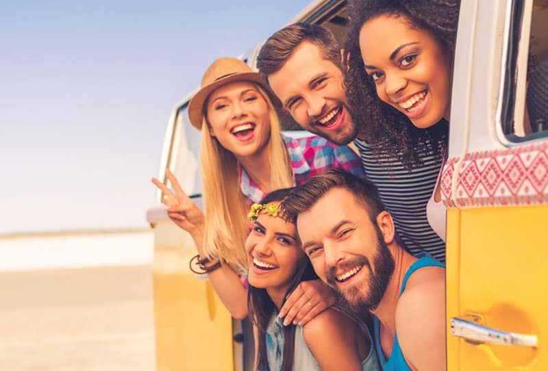 group of people posing for a picture at the van's door entrance