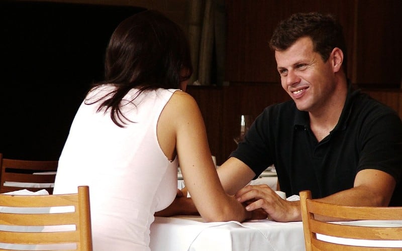 Uomo felice di fronte a una donna a un tavolo