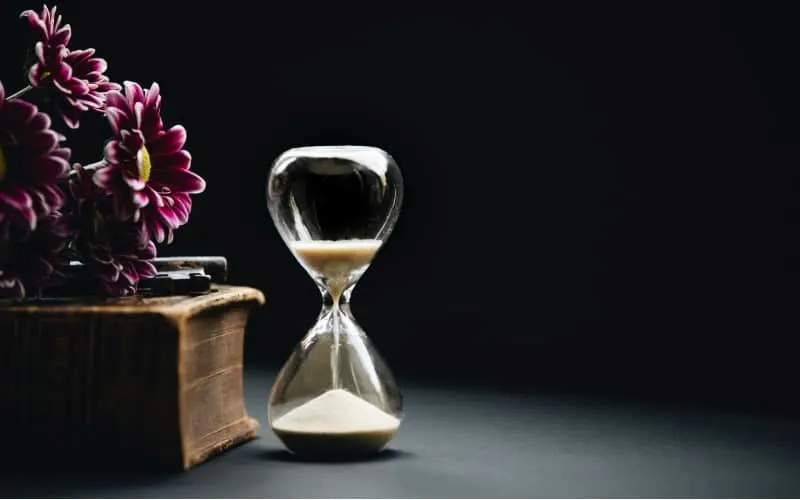 Hourglass and flowers in dark background