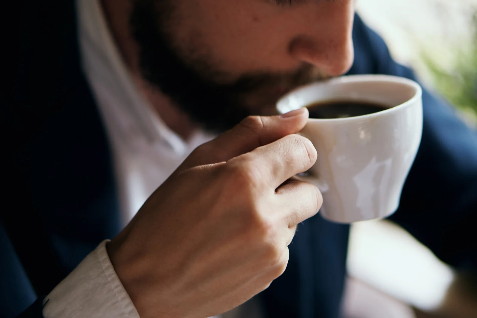 man in suit drinking coffee
