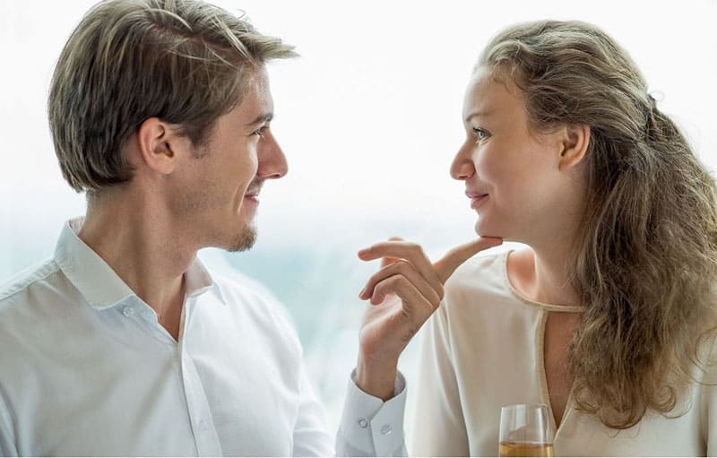 man looks at his girlfriend with love touching her chin