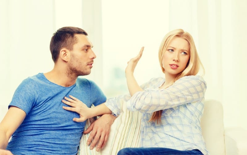 Man trying to talk to angry woman sitting next to each other